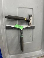 Photo shows two metal bending hammers with black handles on grey plastic background.