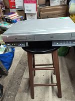 Front view of Toshiba VHS/DVD player showing VHS slot, DVD tray, control buttons, and AV input ports