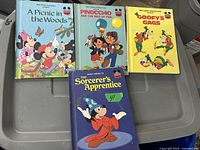Four vintage Disney children's books displayed showing front covers: A Picnic in the Woods, Pinocchio and the Isle of Fun, Goofy's Gags, and The Sorcerer's Apprentice.