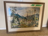 Full front view of framed landscape painting leaning against a wall