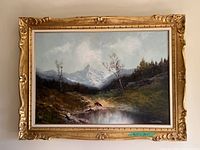 Full front view of the large framed mountain landscape painting showing the ornate gold frame and the overall artwork.