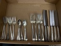 Overall view of all forks, spoons and knives in cardboard box