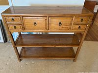 Front view of console cabinet showing five drawers and two lower shelves