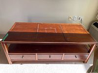 Full view of the wooden coffee table showing top, drawers, and shelf.