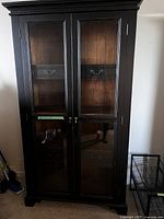 Front view of closed cabinet showing black exterior and glass doors