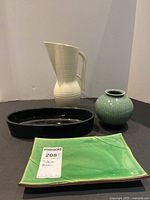 Full lot photo showing all four decorative ceramic pieces together on a black surface against white background.