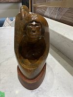 Frontal view of sculpture showing human face side and hollowed section