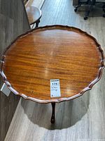 Photo of the vintage wooden round table showing scalloped edge and wood finish.