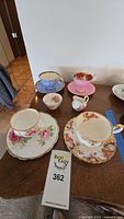 Overview of all teacups, saucers, creamer, sugar bowl and lot tag