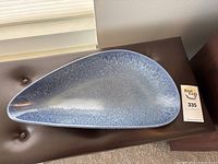 Top view showing the smooth blue speckled glaze and triangular shape of the Knabstrup platter.