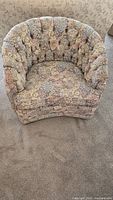 Front view of the custom upholstered tufted back chair with floral patterned upholstery.