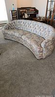 Contoured custom curved sofa with tufted back straight view, showing floral upholstery and shape