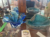 Blue hobnail style dish and chalet style dish placed on shelf with mirror reflections