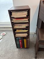 Front view showing the wooden stand filled with vintage sheet music and binders
