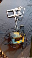 DeWalt hammer drill lying flat with one metal mixing paddle attachment placed adjacent