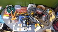Overview of entire lot showing tools, clamps, a caulk gun, sanding discs, and other items on a small table