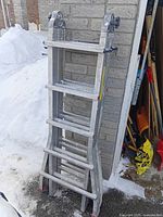 Overall collapsed ladder against a brick wall