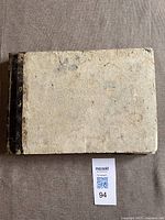 Top view of worn hardback book showing cover and general condition