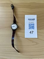 Top view of entire antique wristwatch showing dial and full strap.