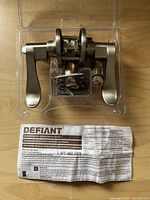 Defiant door lockset inside clear plastic packaging with instruction manual visible