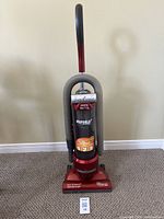 Front view of the full Eureka EZ Kleen upright vacuum showing red color, upright handle, and hose attachment.