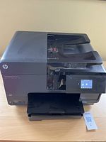 Front view of the HP OfficeJet Pro 8610 printer showing control panel with touchscreen and paper output tray.