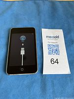 Front view of iPod Touch with screen on showing connect to iTunes cable icon