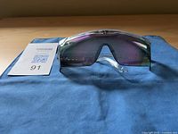 Front view of Lug sunglasses showing tinted lenses with purple-green color shift and clear frame.