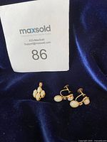 Full lot on dark blue velvet: one pendant and pair of clip-on earrings