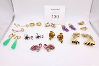 Ten pairs of assorted vintage clip-on earrings with various colored stones and metal finishes.
