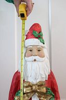 Front view of ceramic Santa with tape measure showing 36 inch height