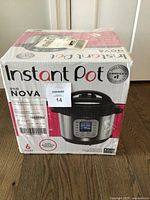Box of Instant Pot Duo Nova 6 Quart in original shrink wrap showing front with product image and branding.