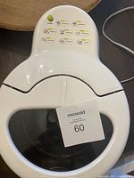 Top view of white air fryer showing the clear lid with 'ACTIFRY' embossed and a sticker with lot number 60.