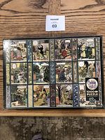 Photo of Cobble Hill puzzle box featuring The Seasons comic-style artwork in grid of scenes with whimsical characters and animals