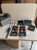 Full layout of tools on table including toolbox, wrenches, screwdrivers, socket sets