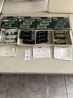 Four original KATO 3 car kits in boxes with assembled cars and instruction sheets laid out on a table