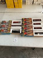 View of the full lot showing multiple original packaged train cars and locomotives on a white table.