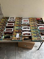 Photo of multiple Athearn H/O scale train cars in original packaging laid out on a table showing variety and quantity.