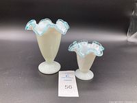 Photo of two vintage Fenton vases, large and small, with aqua blue crested ruffled rims on white opaque glass bodies, displayed on black background with lot number card