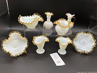 Front photo showing the full set of 8 vintage Fenton Gold Crest pieces arranged on raised acrylic blocks with ruffled gold-trimmed, white opalescent glassware pieces spaced evenly.