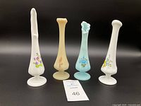 Front view of all four vintage hand painted bud vases showing floral designs and varied top shapes.