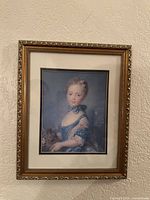 Frontal photo of the framed print showing the girl holding a kitten in a detailed blue dress and ornate gold frame.