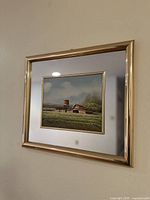 Full view of the framed painting showing the farmhouse scene with the gold frame and white and gold matting, also showing the mirror section of the frame.