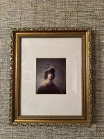 Frontal view of vintage framed print of Rembrandt's self-portrait, showing the ornate gold frame and matting around the print.