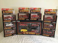 Overview photo showing all 11 die-cast Fire Heroes vehicles and the Classic American Fire Apparatus Set in original boxes arranged on a table.