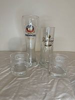 Four beer and whiskey glasses showing brand logos from Erdinger, Radeberger, Jack Daniel's, and Philadelphia Flyers on a neutral background.