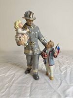 Front view of the Lenox porcelain firefighter figurine holding a child and a boy with an American flag.