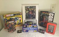 Wide view of all items including framed photo, boxed diecast cars, action figure, and signed tin box.