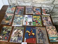 All 15 vintage comic books arranged in three rows on a table, showing front covers clearly.