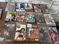 Top view of all 15 vintage comic books laid out on a wooden table, showing colorful and illustrated covers with various titles and characters.